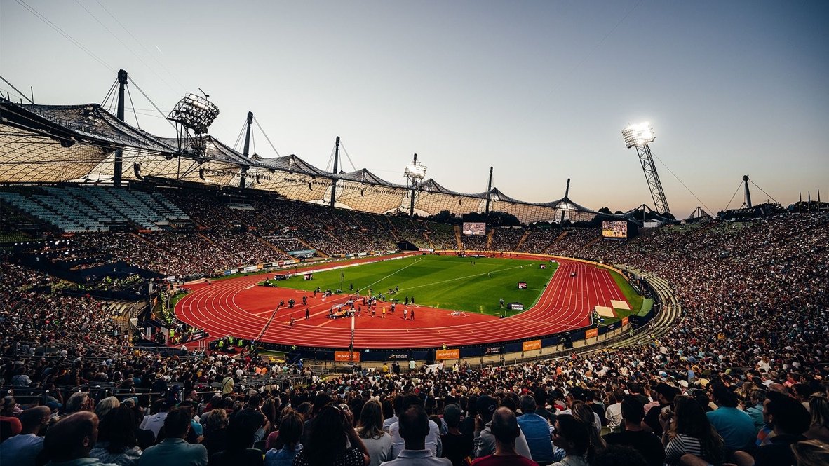 Voll besetztes Olympiastadion München in der Abenddämmerung während eines Leichtathletik-Wettkampfs